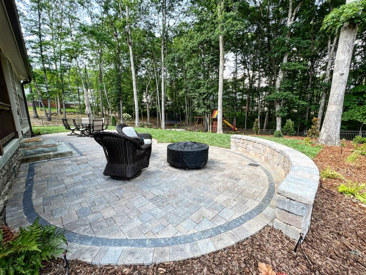 Geometric paver patio with fire pit and retaining wall