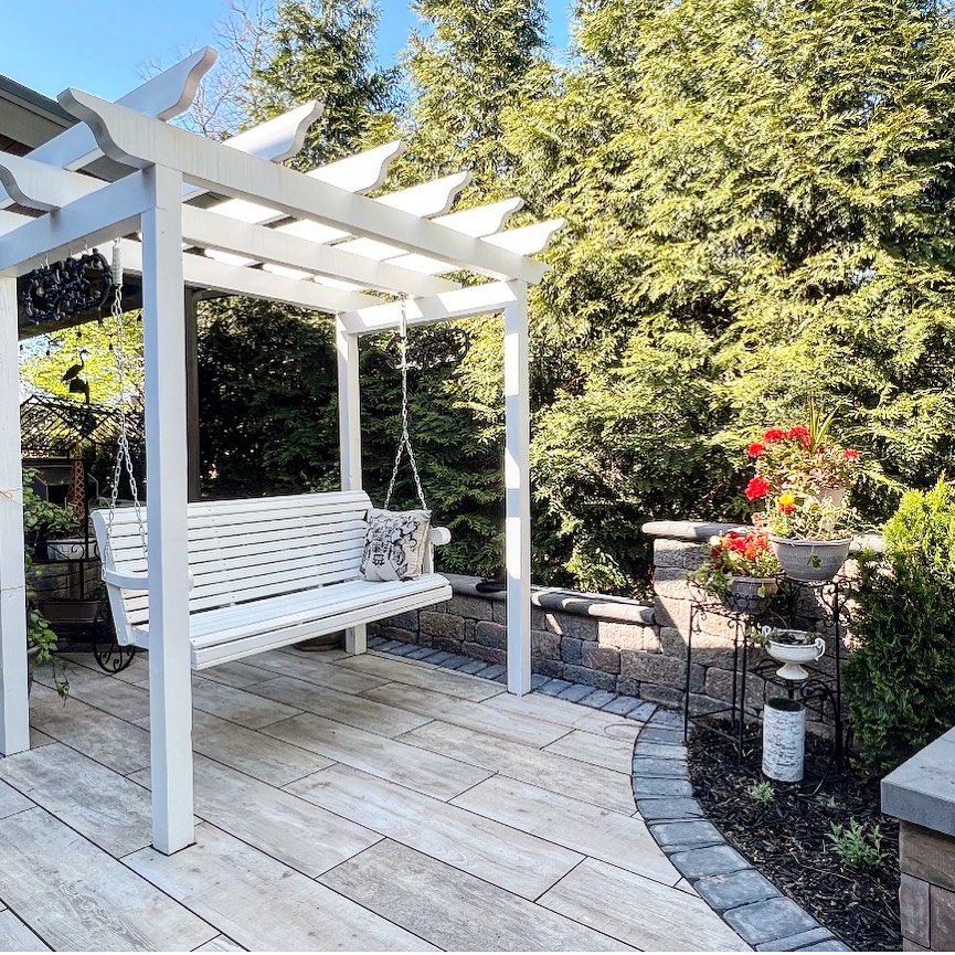 Tiled patio with a pergola and bench swing