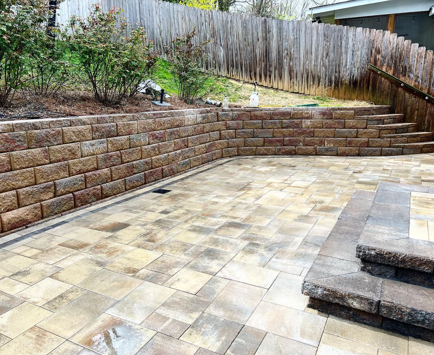 Block retaining wall surrounding a geometric paver patio design