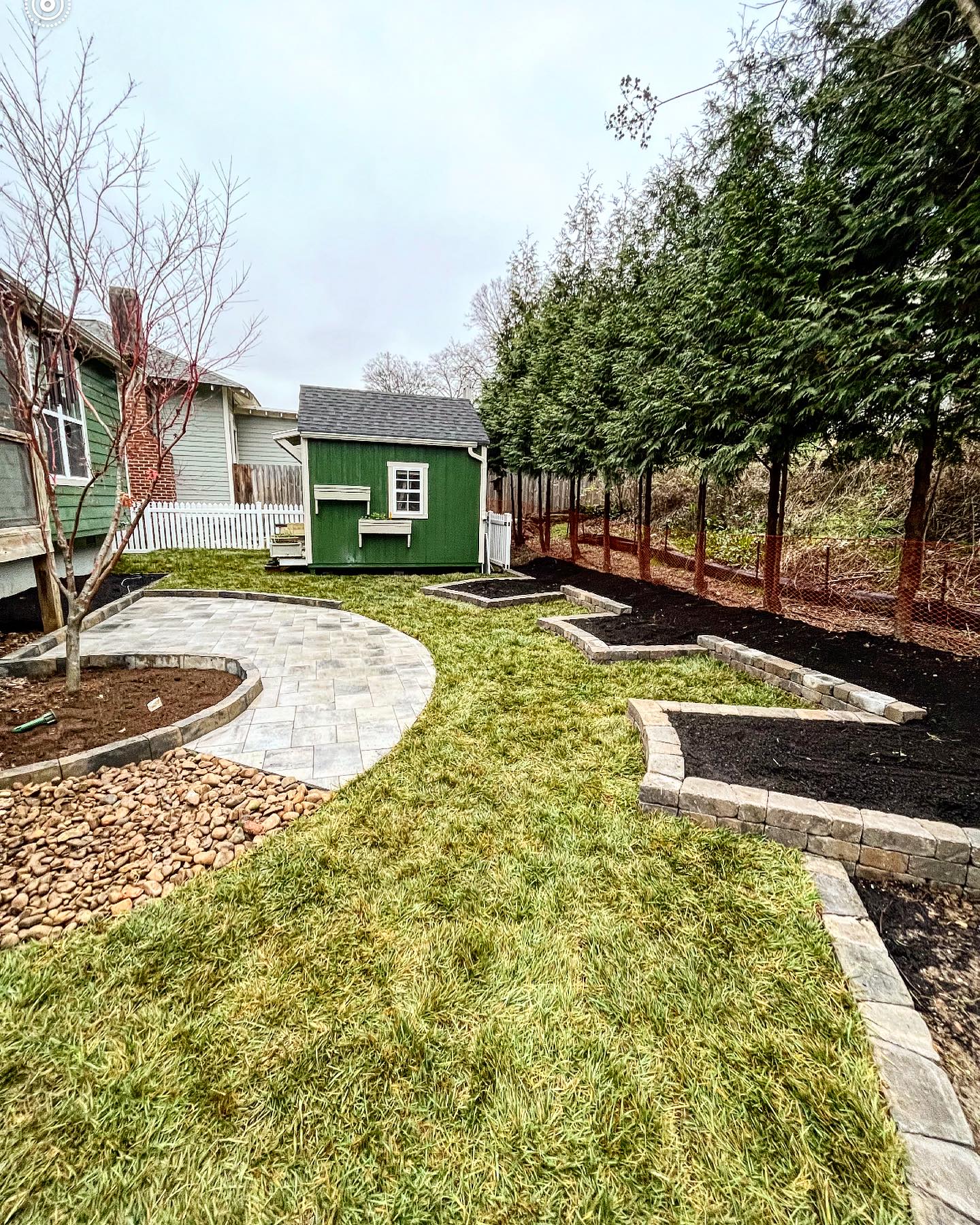 Geometric small backyard design with stone walled flower beds