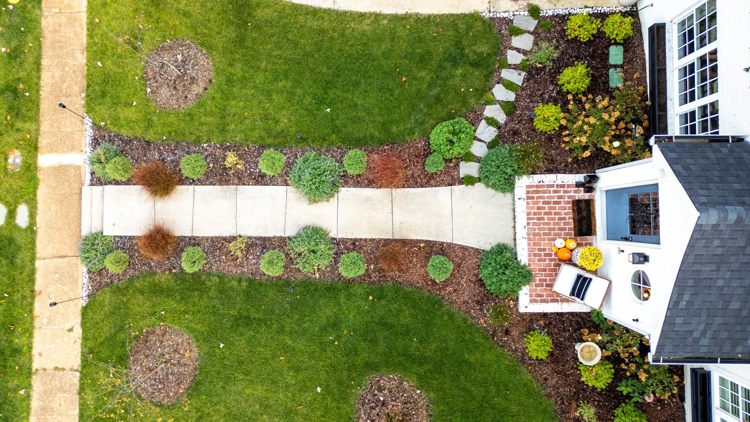 Beautifully manicured geometric front lawn with native shrubs and flower beds